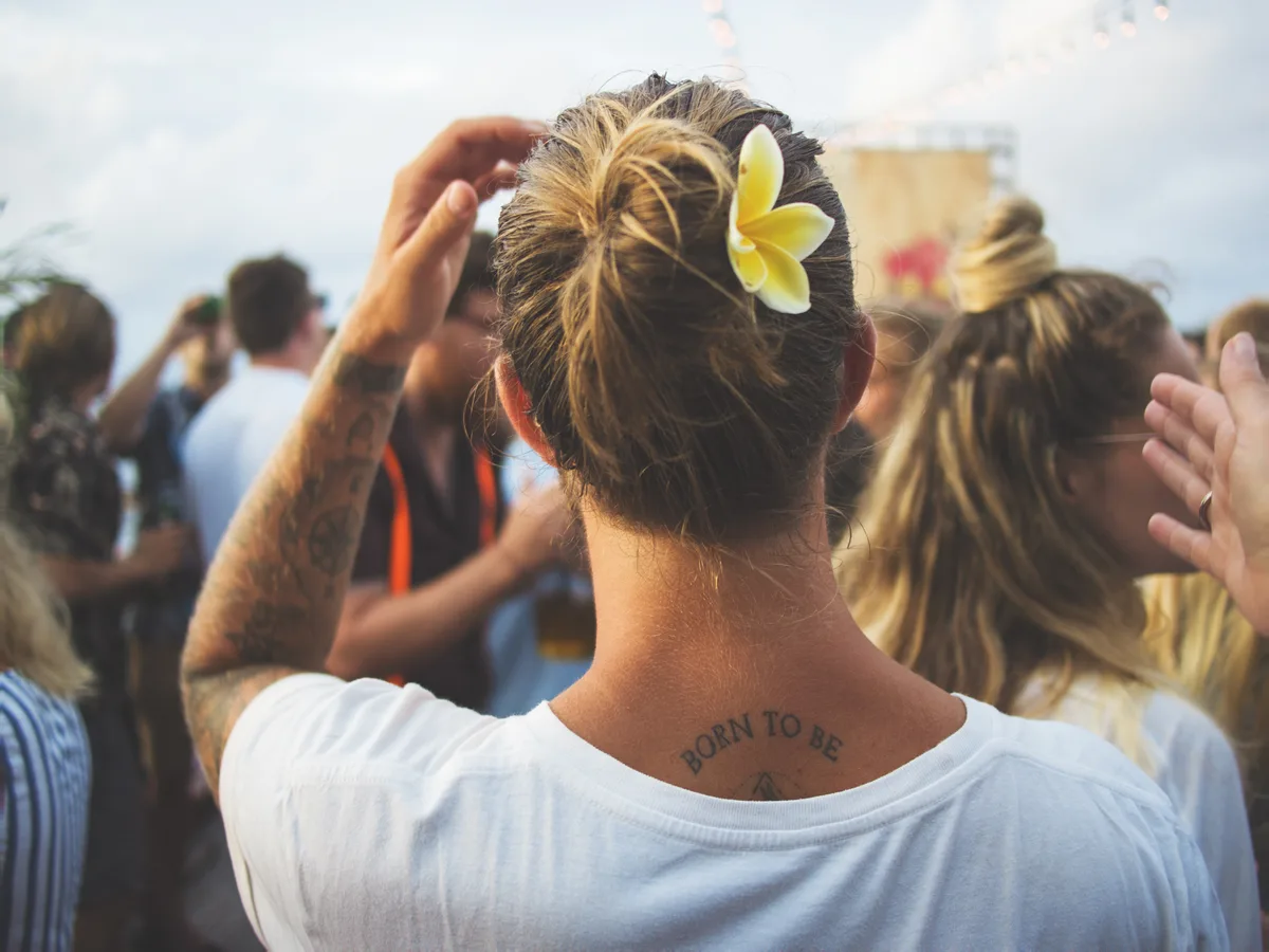 Person in einer sommerlichen Festivalmenge, von hinten fotografiert