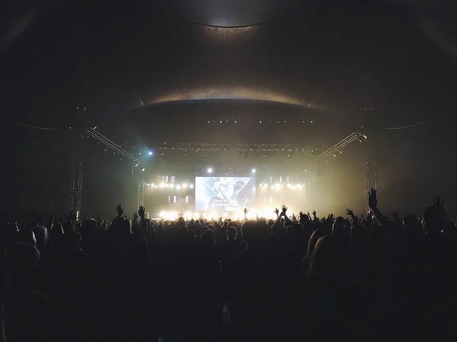 Audience facing an illuminated stage in a concert hall